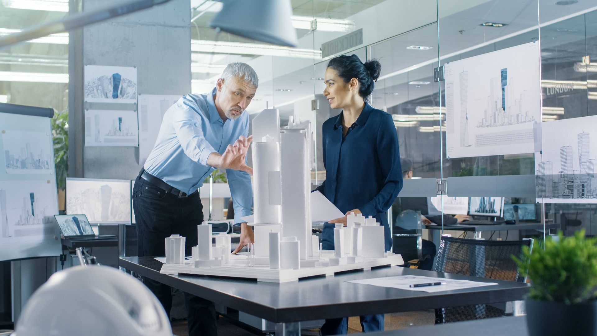 Chief Male Architect and Female Engineer Work with City Buildings Model. Bright People Work as Urban Planners.